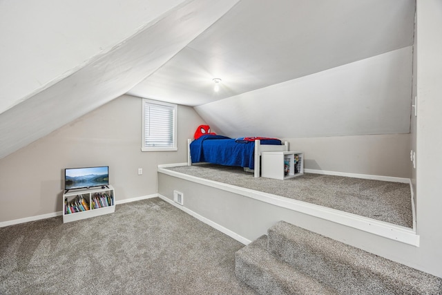 carpeted bedroom with lofted ceiling, visible vents, and baseboards