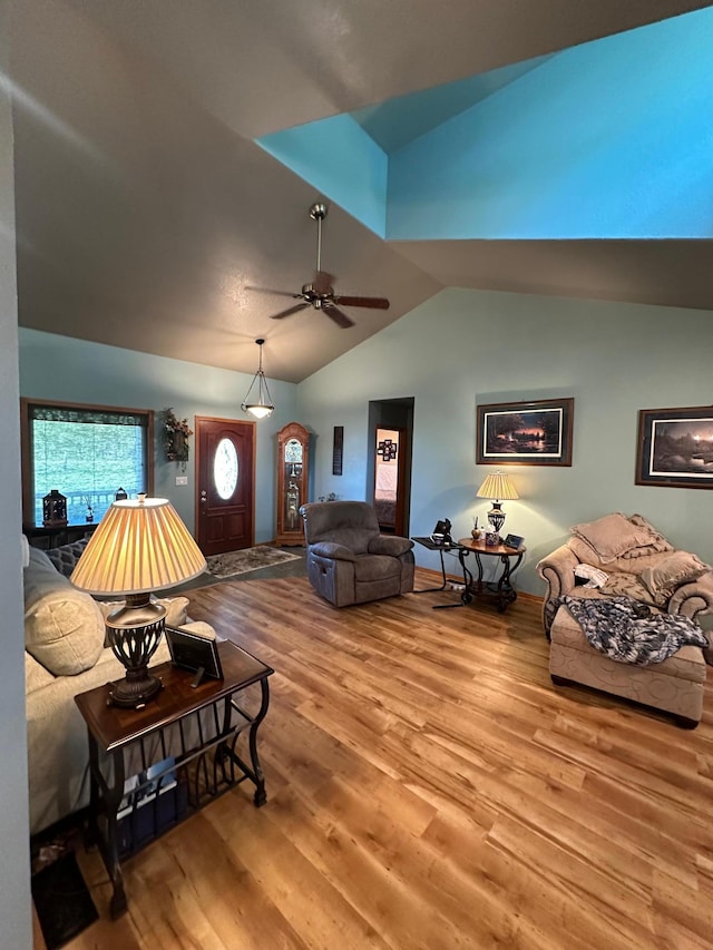 living room featuring vaulted ceiling, wood finished floors, and a ceiling fan