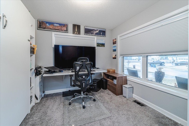 carpeted home office with visible vents, baseboards, and a textured ceiling