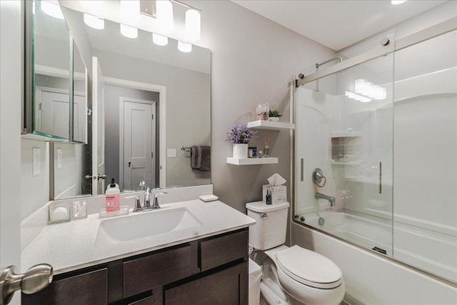 bathroom with combined bath / shower with glass door, vanity, and toilet