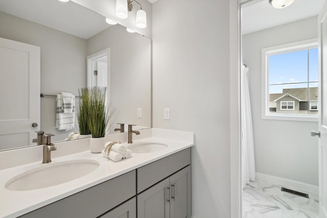 full bathroom featuring marble finish floor, a sink, visible vents, and baseboards