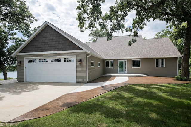 view of front of property featuring driveway, a front lawn, an attached garage, and a shingled roof