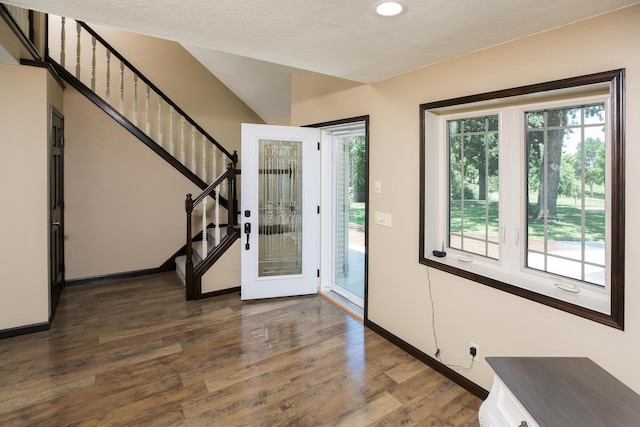 entryway with plenty of natural light, stairs, baseboards, and wood finished floors