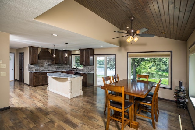 dining room with baseboards, vaulted ceiling, and dark wood-style flooring