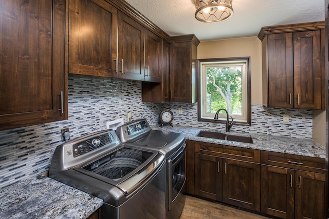 washroom with washer and dryer, cabinet space, a sink, and a textured ceiling