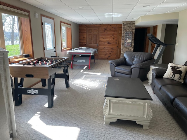 rec room featuring wooden walls, a paneled ceiling, and light colored carpet