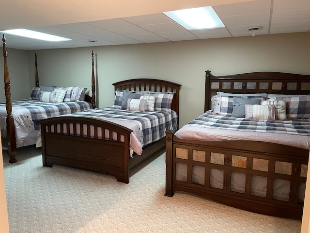 bedroom featuring light carpet, visible vents, and a drop ceiling