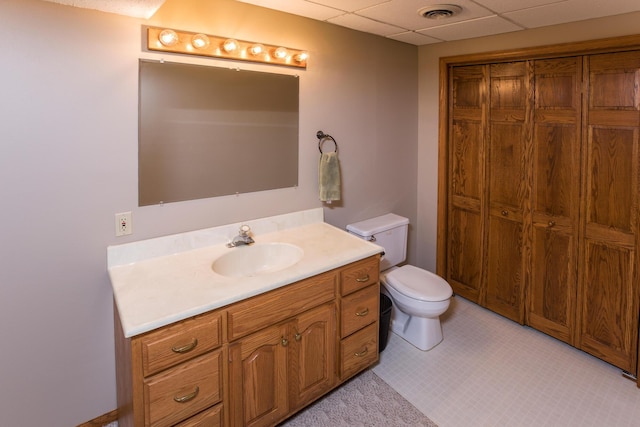 bathroom featuring a paneled ceiling, visible vents, toilet, and vanity