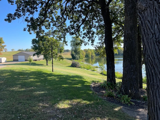 view of yard featuring a water view, an outbuilding, and an outdoor structure