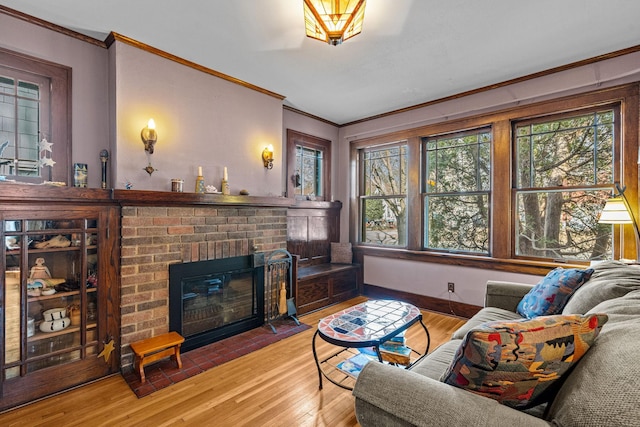 living room featuring a brick fireplace, crown molding, and wood finished floors