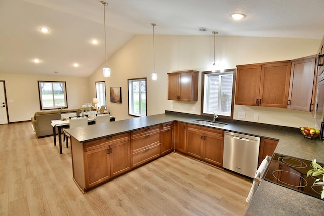 kitchen featuring light wood finished floors, brown cabinetry, a sink, dishwasher, and a peninsula