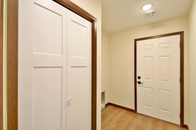 hallway featuring light wood-type flooring and baseboards