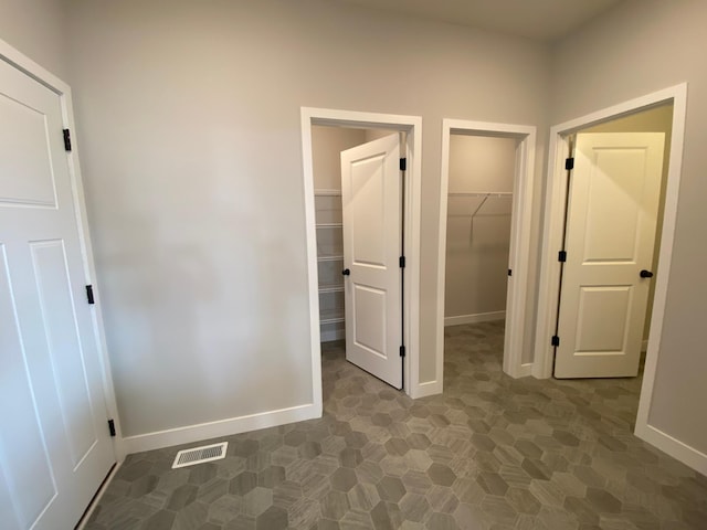 corridor with baseboards and visible vents