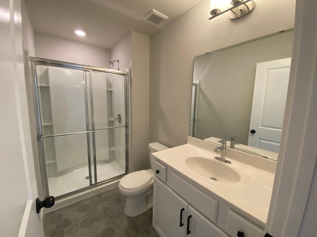 full bath featuring toilet, a shower stall, visible vents, and vanity