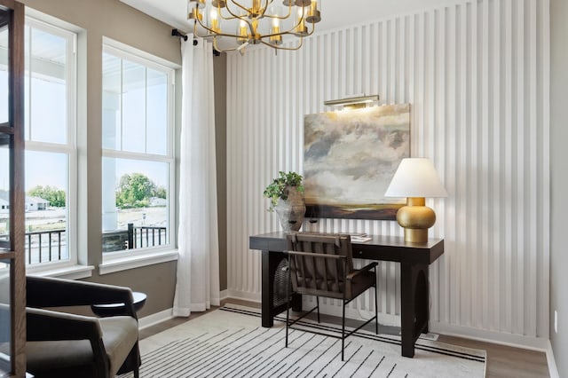 office area with wallpapered walls, an inviting chandelier, wood finished floors, and baseboards