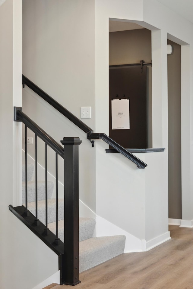 staircase with wood finished floors and baseboards