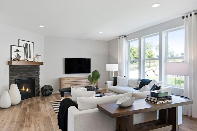 living room with baseboards, a fireplace, wood finished floors, and recessed lighting