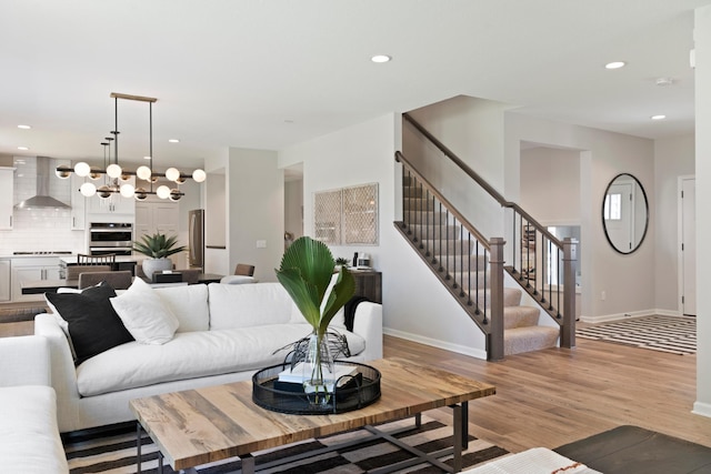 living area with light wood-type flooring, baseboards, recessed lighting, and stairs