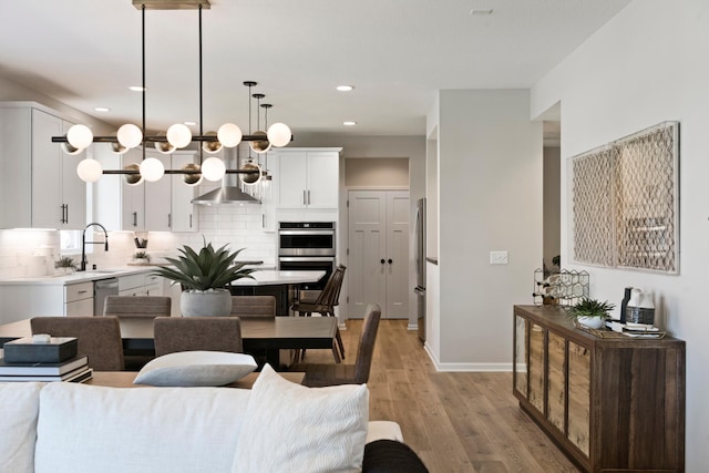 dining room featuring light wood-style floors, baseboards, and recessed lighting