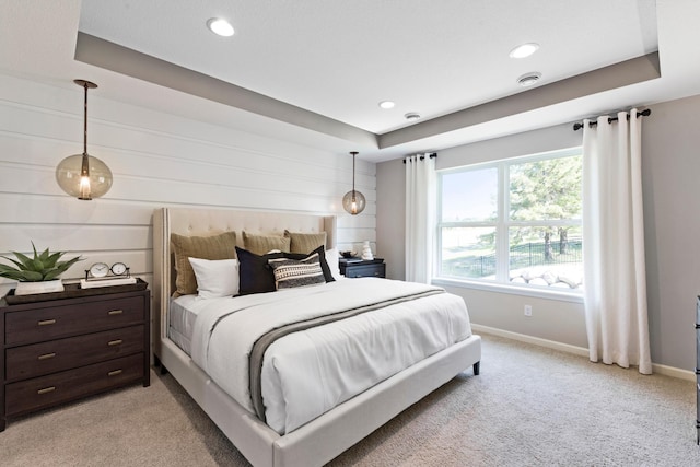 bedroom with visible vents, baseboards, a raised ceiling, and light colored carpet