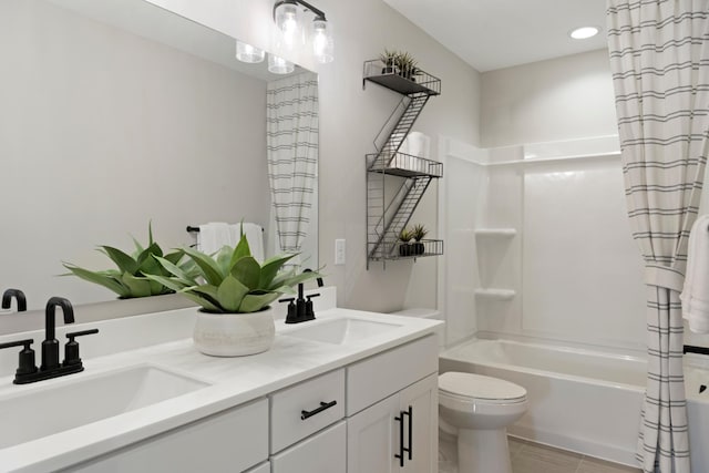 bathroom featuring double vanity, shower / tub combo, a sink, and toilet