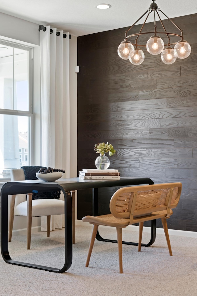 carpeted dining area featuring wood walls