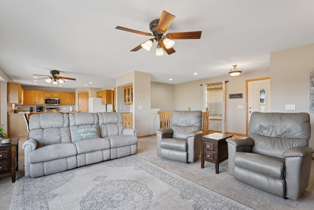 living area with a ceiling fan, recessed lighting, light colored carpet, and baseboards