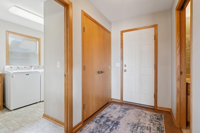 foyer featuring baseboards and independent washer and dryer