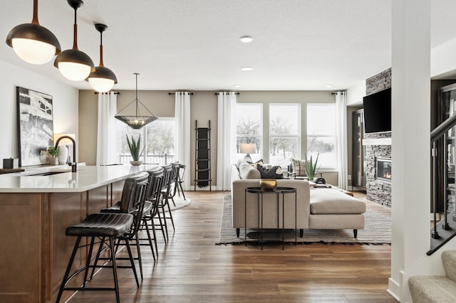 interior space with a textured ceiling, a fireplace, baseboards, stairway, and dark wood finished floors