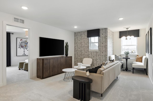 carpeted living area featuring recessed lighting, visible vents, a notable chandelier, and baseboards