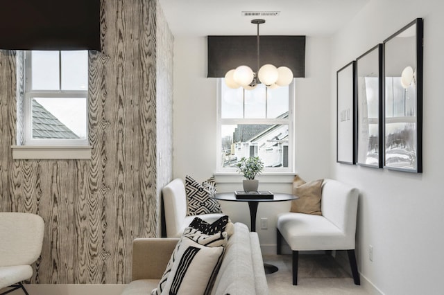 sitting room with plenty of natural light, visible vents, and a notable chandelier