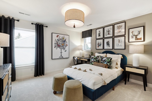 bedroom featuring multiple windows, visible vents, and light colored carpet