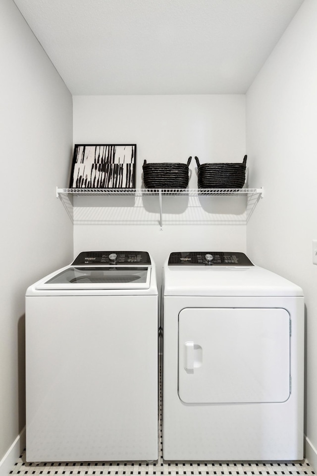 washroom featuring laundry area, washer and clothes dryer, and baseboards