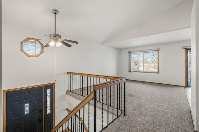 hall featuring lofted ceiling, carpet, and baseboards