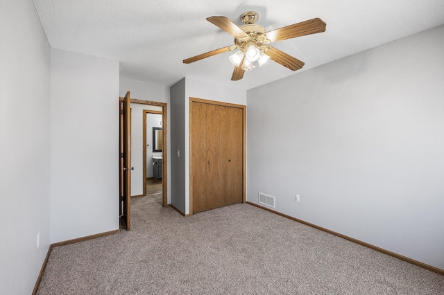 unfurnished bedroom featuring baseboards, a textured ceiling, visible vents, and a closet