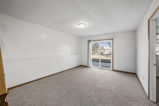 carpeted empty room with baseboards and a textured ceiling