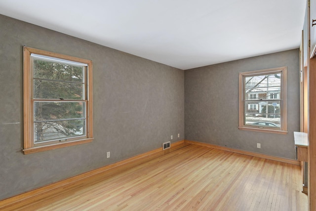 empty room featuring visible vents and wood finished floors