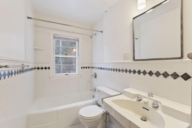 bathroom with shower / bath combination, a wainscoted wall, tile walls, and toilet