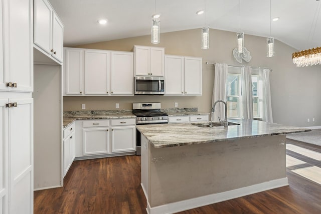 kitchen featuring dark wood-type flooring, lofted ceiling, a sink, stainless steel appliances, and light stone countertops