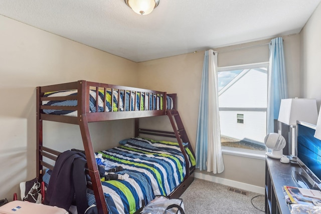 carpeted bedroom featuring visible vents, a textured ceiling, and baseboards