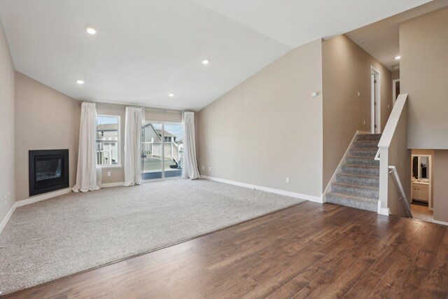7295 Parson Ct NE, Otsego, MN 55330 - unfurnished living room featuring a glass covered fireplace, stairway, wood finished floors, and baseboards