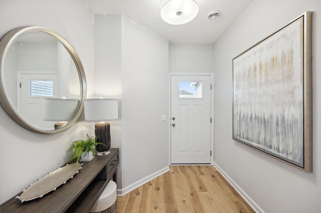 foyer featuring light wood-style flooring and baseboards