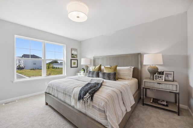 carpeted bedroom with visible vents and baseboards