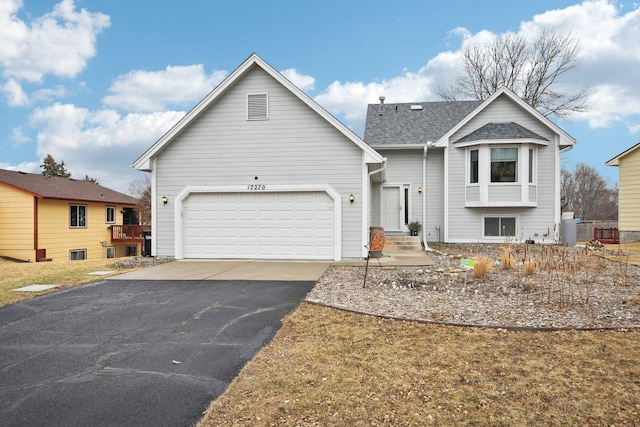 view of front facade with aphalt driveway, a shingled roof, and an attached garage