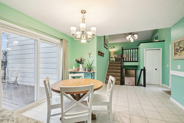 dining space featuring light tile patterned floors, a textured ceiling, a notable chandelier, baseboards, and stairway