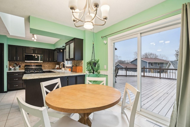 dining space with light tile patterned flooring, visible vents, and a notable chandelier