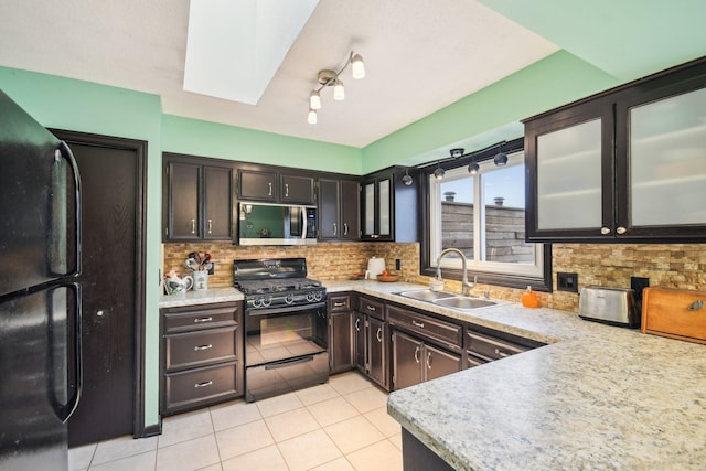 kitchen with decorative backsplash, light countertops, a sink, and black appliances