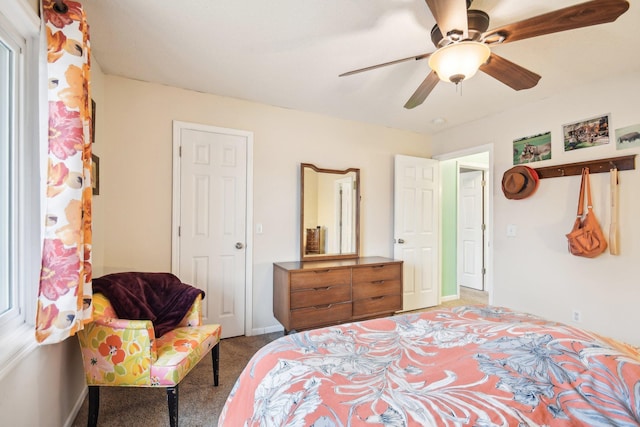 bedroom with a ceiling fan, light carpet, and baseboards