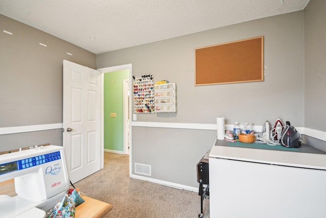 carpeted bedroom featuring baseboards, visible vents, a textured ceiling, and refrigerator