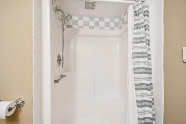 bathroom with curtained shower and visible vents